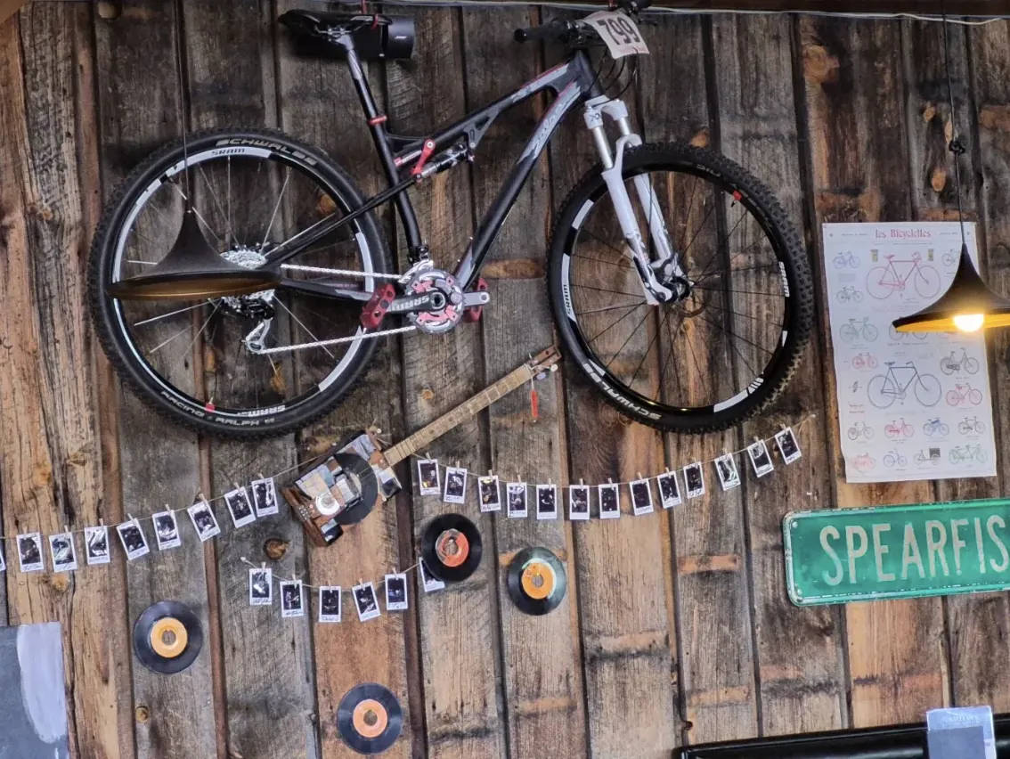 Mountain bike mounted on a reclaimed wood wall with vinyl records and a Spearfish street sign