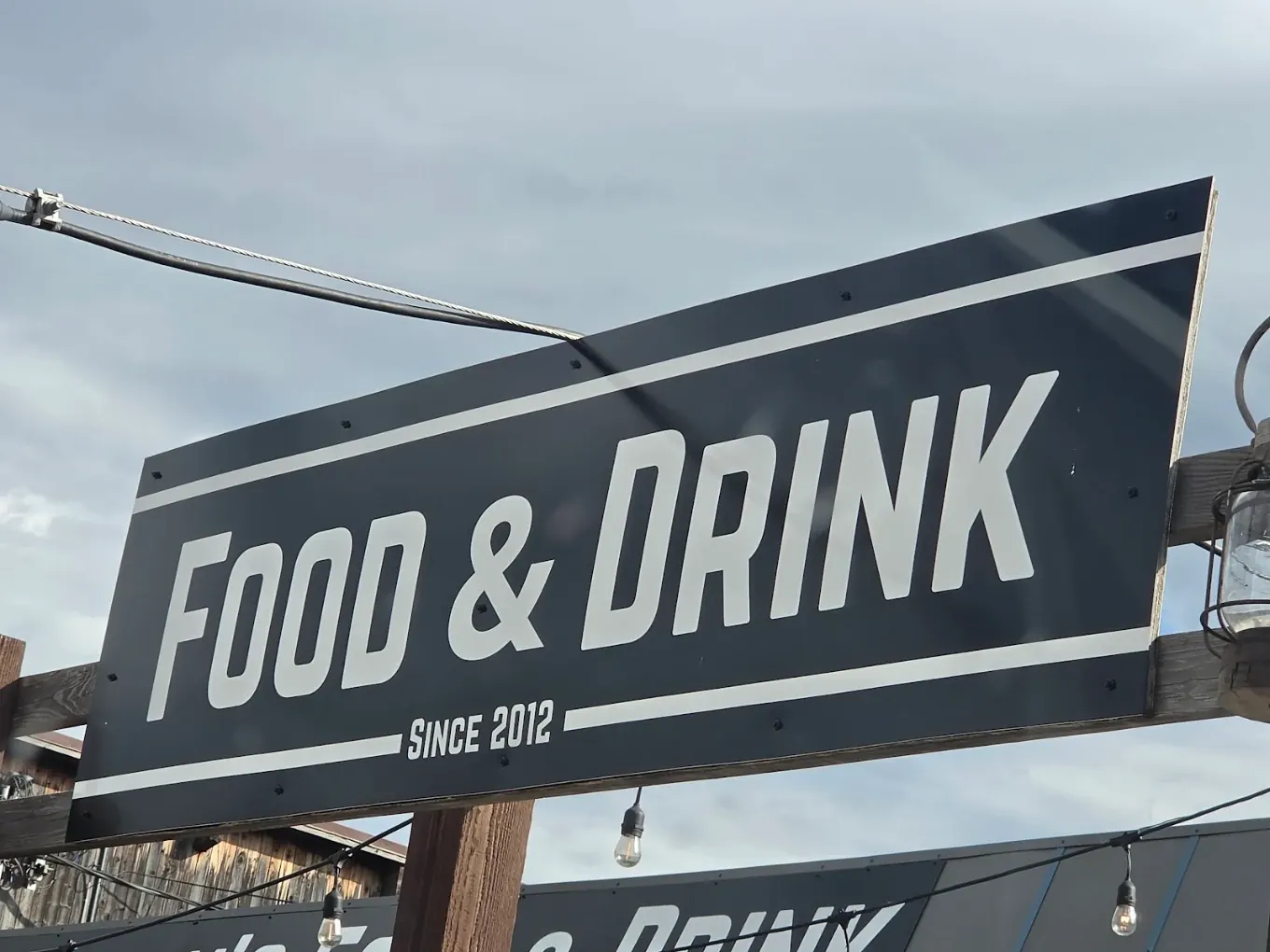 Killian's Food & Drink Since 2012 sign against a cloudy Spearfish sky