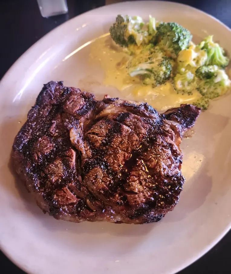 Grilled ribeye steak plated with cheesy broccoli at Killian's in Spearfish, SD