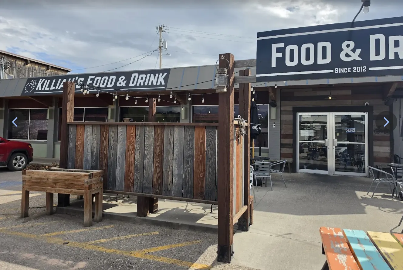 Killian's Food & Drink storefront with wooden patio fence and string lights in Spearfish, SD in the northern Black Hills